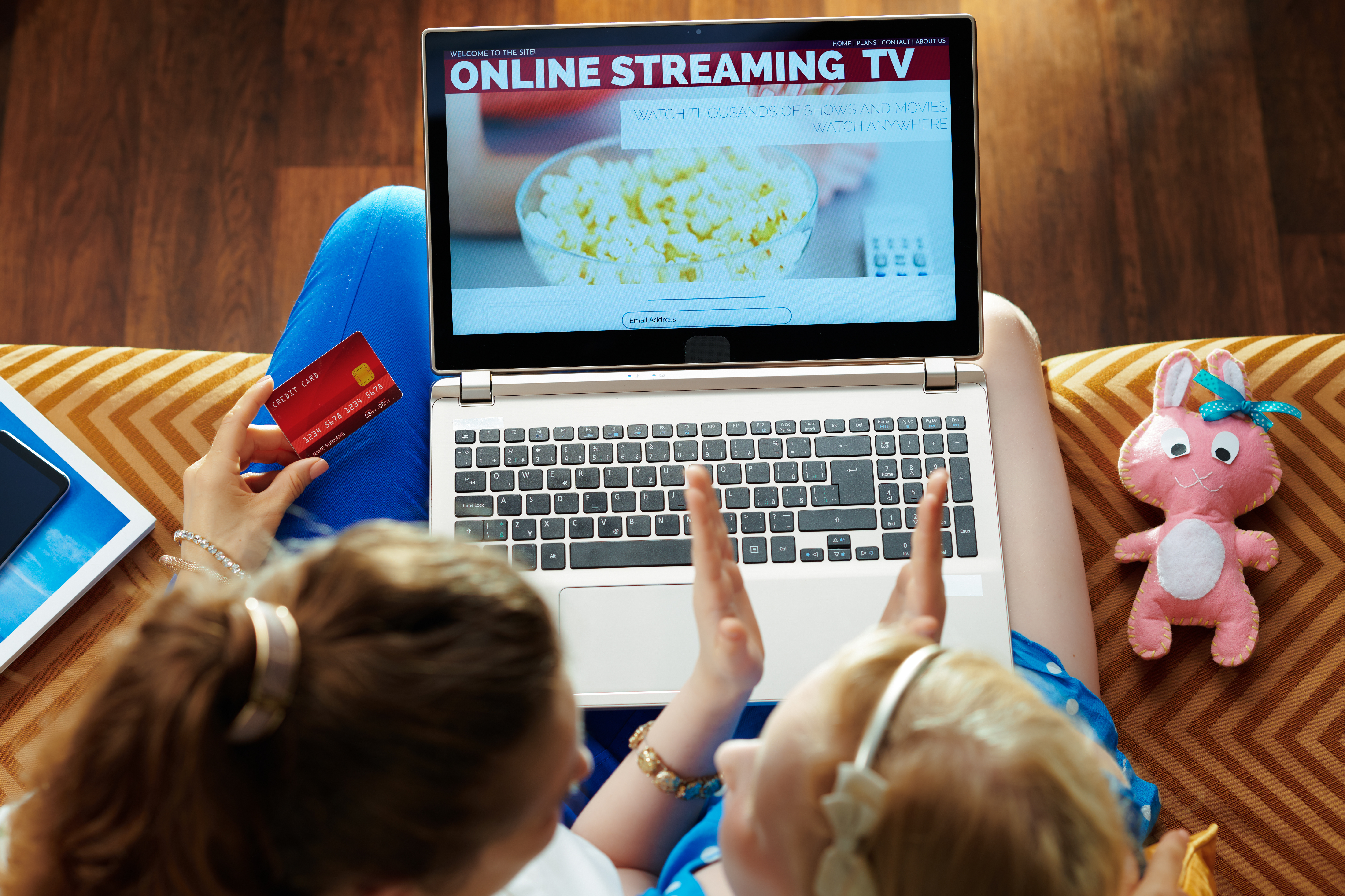 mother and child watching online streaming tv with a laptop on the couch