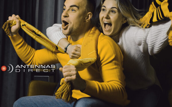 Man and women watching an exciting sports game on TV.