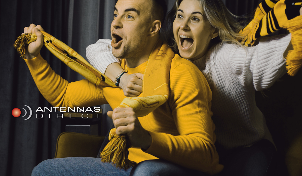 Man and women watching an exciting sports game on TV.